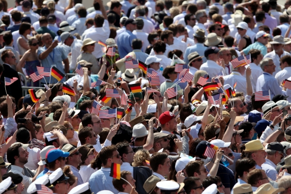 Zuschauer mit Fähnchen der USA und Deutschlands vor dem Brandenburger Tor in Berlin, über dts Nachrichtenagentur