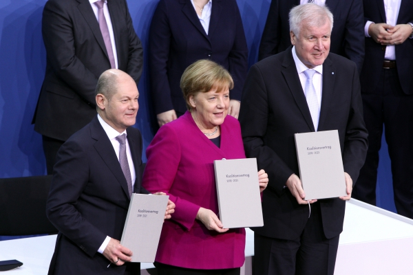 Scholz, Merkel und Seehofer mit Koalitionsvertrag 2018-2021, über dts Nachrichtenagentur