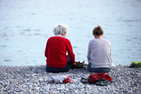 Alte und junge Frau sitzen am Strand, über dts Nachrichtenagentur