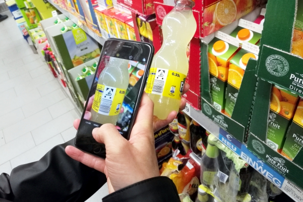 Kunde mit Smartphone im Supermarkt, über dts Nachrichtenagentur