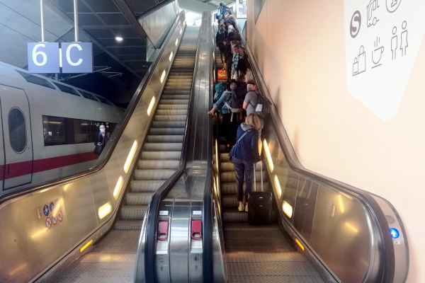 Menschen mit Schutzmasken auf einer Rolltreppe, über dts Nachrichtenagentur